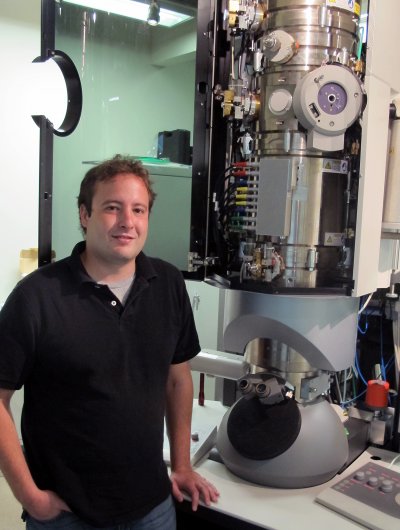 Joshua Razink stands by a CAMCOR-based HR-TEM used in new study