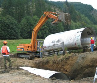 Replacing a small culvert to help passage of spawning salmon and other fish. Photo by the Siuslaw National Forest. 