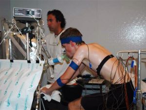 Image shows a study subject riding a stationary bicycle in the UO's environmental chamber